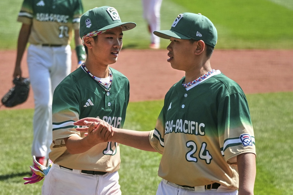 Taiwan's Chen Qi-Sheng (24), right, and Chang Chun-Po celebrate after getting the final out of the International Championship baseball game against Aruba at the Little League World Series tournament in South Williamsport, Pa., Saturday, Aug. 23, 2025. (AP Photo/Gene J. Puskar)