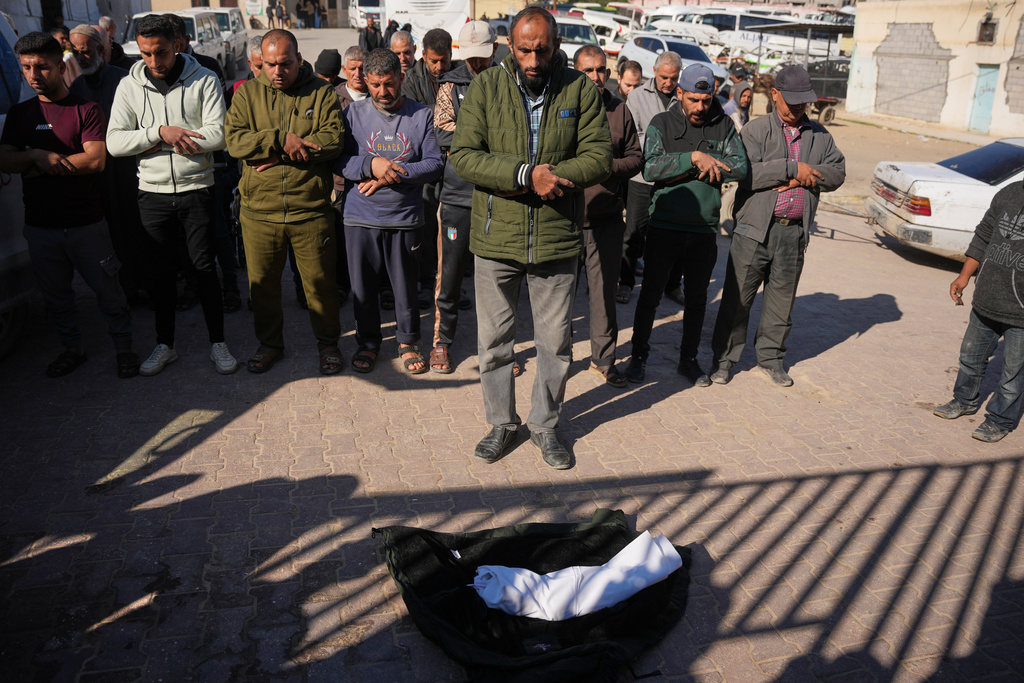 The Abdeen family performed the funeral prayer for their 29-day-old infant son, Saeed Abdeen, who, according to health authorities, died due to the cold weather, at Nasser Hospital in Khan Younis, southern Gaza Strip, Thursday, Dec. 18, 2025. (AP Photo/Abdel Kareem Hana)