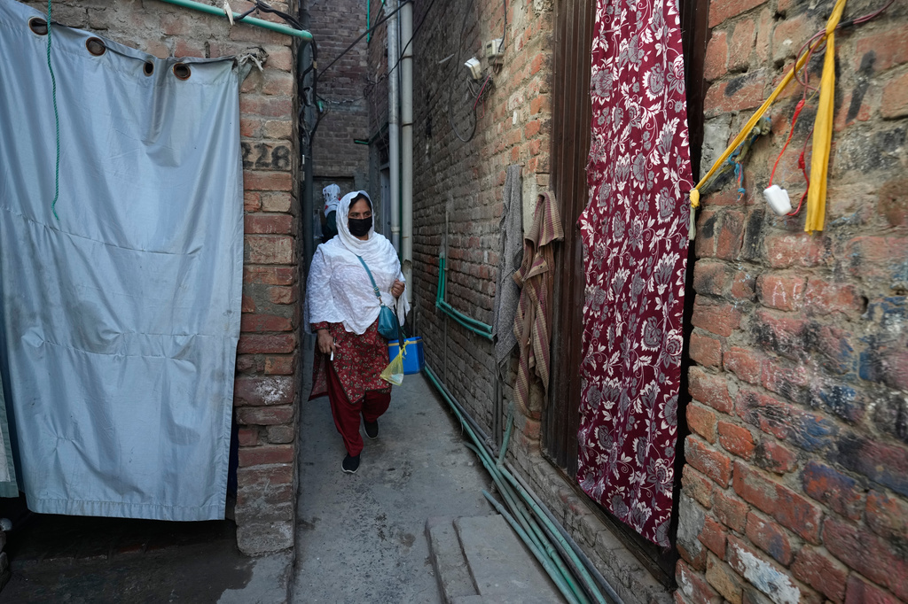 Health workers walk through an ally to administrate polio vaccine among children at a neighbourhood in Lahore, Pakistan, Monday, April 13, 2026. (AP Photo/K.M. Chaudary)