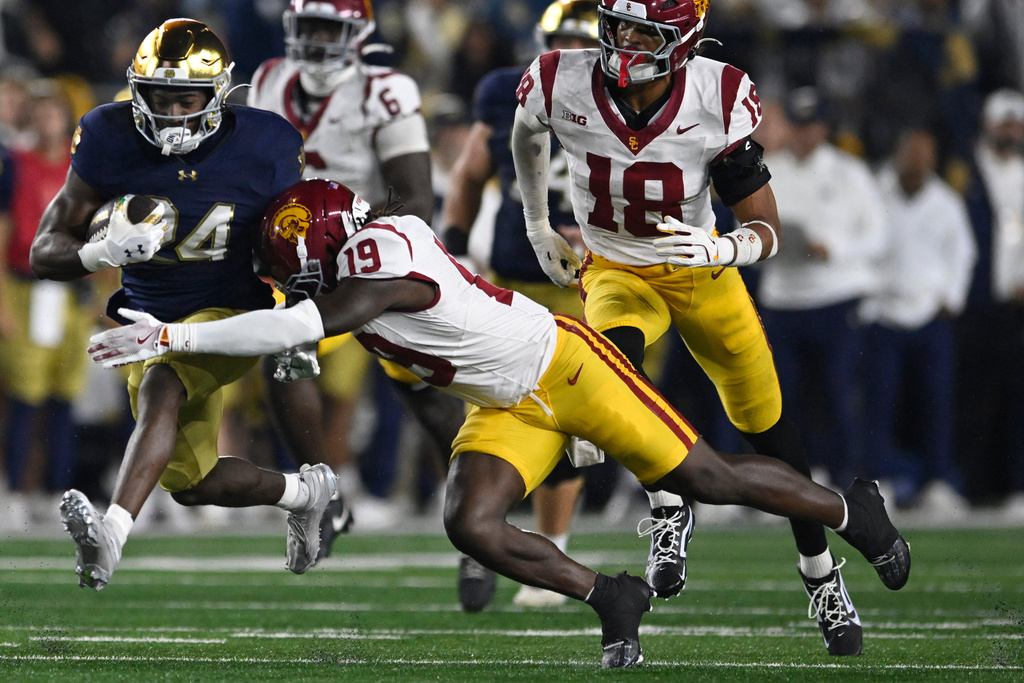 Notre Dame's Jadarian Price (24) rushes against Southern California's Bishop Fitzgerald (19) during the first quarter of an NCAA college football game Saturday, Oct. 18, 2025, in South Bend, Ind. (AP Photo/Paul Beaty)