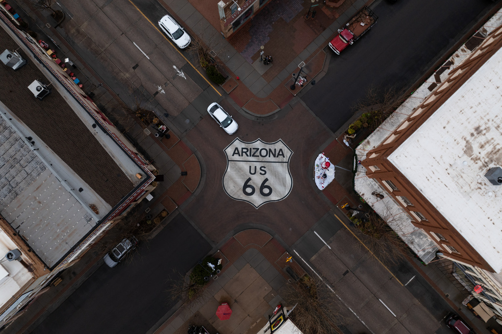 Motorists travel through an intersection marked with a U.S. 66 shield in Winslow, Ariz., a town on the historic highway, Thursday, Nov. 20, 2025. (AP Photo/Jae C. Hong)