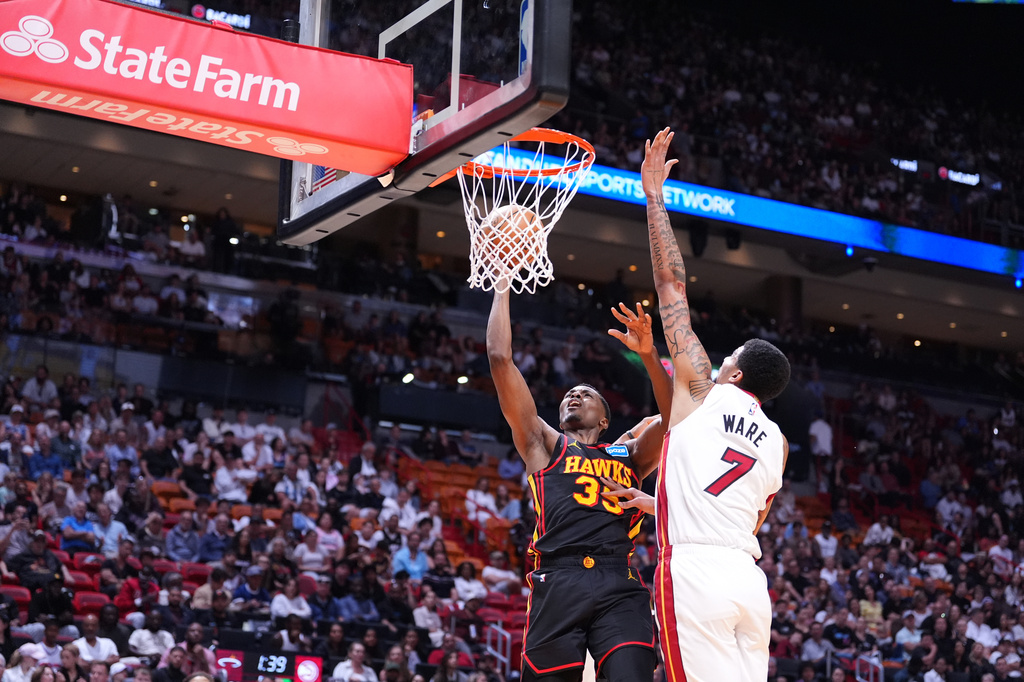Atlanta Hawks center Christian Koloko (35) scores defended by Miami Heat center Kel'el Ware (7) during the first half of an NBA basketball game, Sunday, April 12, 2026, in Miami. (AP Photo/Rebecca Blackwell)