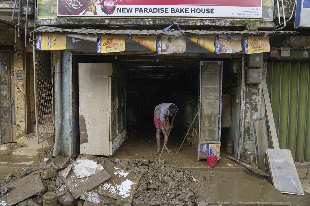 A man cleans the mud and slush from his shop after floods in Gelioya, Sri Lanka Sri Lanka, Monday, Dec. 1, 2025. (AP Photo/Eranga Jayawardena)