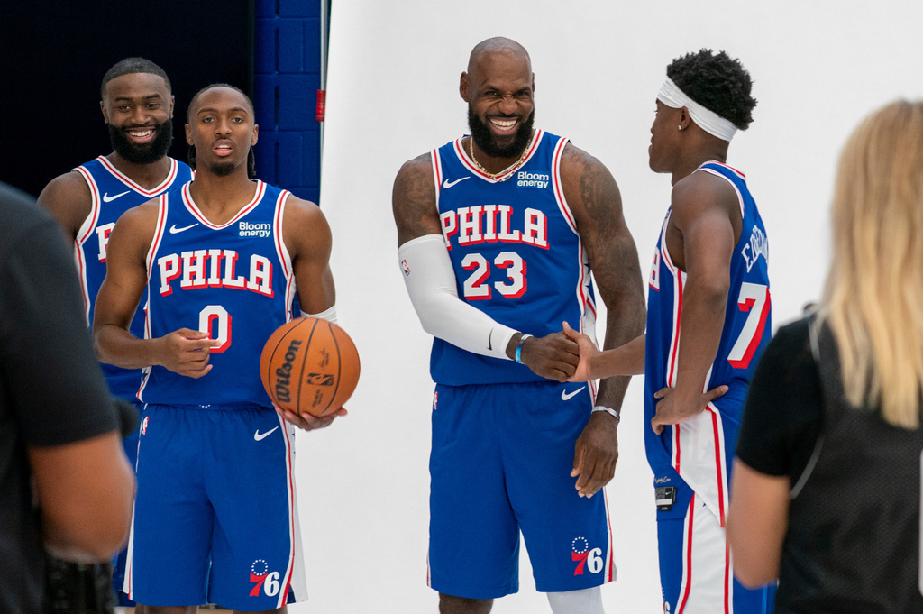 Philadelphia 76ers' LeBron James, center right, greats VJ Edgecombe, right, as they get ready for a group photos with Tyrese Maxey, center left, and Jaylen Brown, left, during the NBA basketball team's media day, Monday, Sept. 28, 2026, in Camden, N.J.. (AP Photo/Chris Szagola)