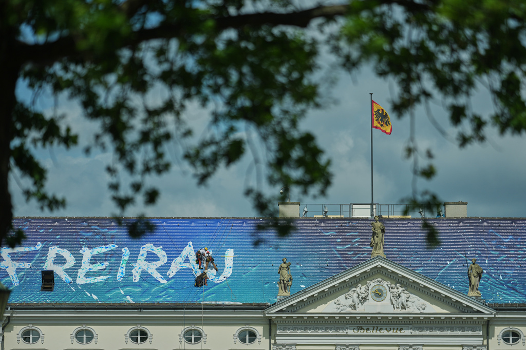 Workers install the artwork "Freiraum Kunst" by Christian Awe on the roof of the German President's residency Bellevue Palace as part of an exhibition of contemporary art at the building in Berlin, Germany, Monday, June 8, 2026. (AP Photo/Markus Schreiber)