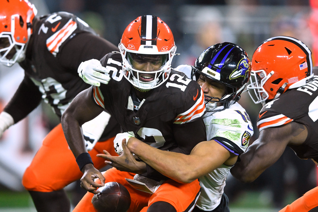 Cleveland Browns quarterback Shedeur Sanders (12) is sacked by Baltimore Ravens safety Kyle Hamilton (14) in the second half of an NFL football game in Cleveland, Sunday, Nov. 16, 2025. (AP Photo/David Richard)