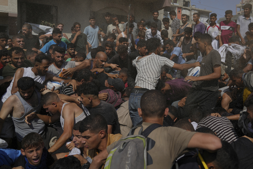 Palestinians struggle to collect humanitarian aid airdropped into Gaza City, northern Gaza Strip, Thursday, Aug. 14, 2025. (AP Photo/Jehad Alshrafi)