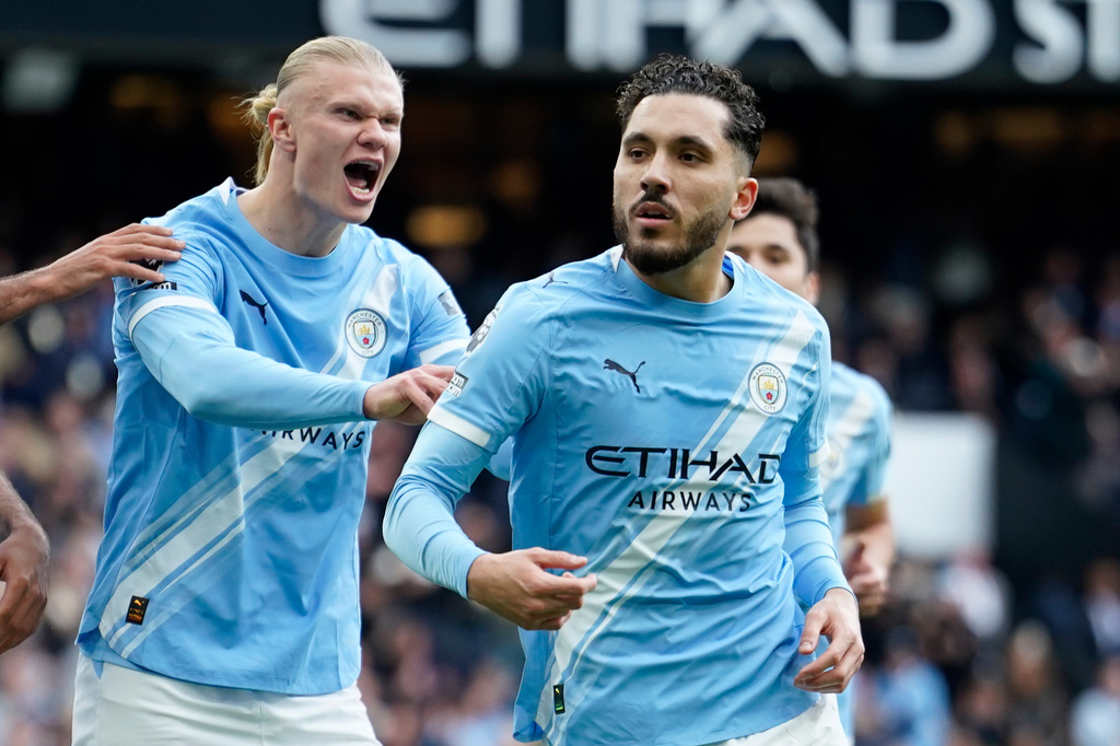 Manchester City's Rayan Cherki celebrates with his teammate Erling Haaland after scoring his side's first goal during the English Premier League soccer match between Manchester City and and Arsenal, in Manchester, England, Sunday, April 19, 2026. (AP Photo/Dave Thompson)
