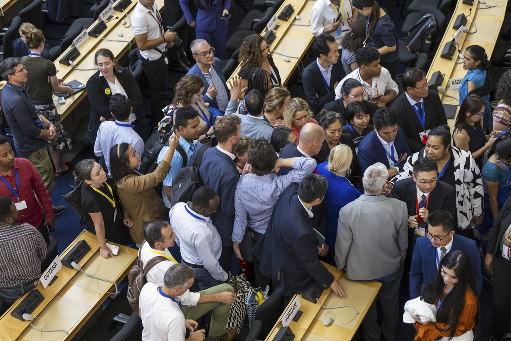 Delegates reacts during a plenary session of Second Part of the Fifth Session of the Intergovernmental Negotiating Committee on Plastic Pollution (INC-5.2), at the European headquarters of the United Nations in Geneva, Switzerland, Thursday, Aug. 14, 2025. (Martial Trezzini/Keystone via AP)