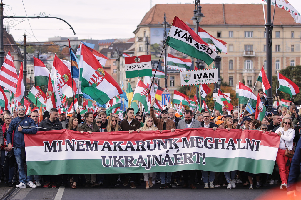 Pro-government demonstrators hold a banner reading "We don't want to die for Ukraine!" in Hungarian during celebrations marking the 69th anniversary of the outbreak of Hungary's 1956 revolution against communist rule and the Soviet Union, in Budapest, Hungary, Thursday, Oct. 23, 2025. (AP Photo/Rudolf Karancsi)