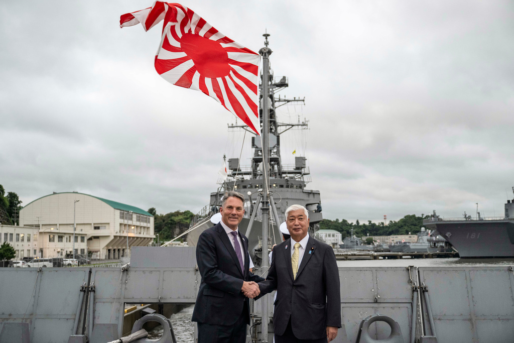 Japan's Defence Minister Gen Nakatani, right, and Australia's Defence Minister Richard Marles shake hands ahead of a joint press announcement aboard the Japan Maritime Self-Defense Force (JMSDF) Mogami-class stealth frigate JS Mikuma at the JMSDF naval base in Yokosuka, Japan, Friday Sept. 5, 2025. (Yuichi Yamazaki/Pool Photo via AP)