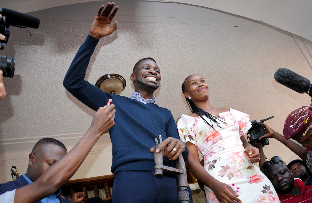 FILE -Pop star-turned-opposition lawmaker Bobi Wine, whose real name is Kyagulanyi Ssentamu, waves to supporters accompanied by his wife Barbara Itungo Kyagulanyi at his home in Kampala, Uganda, Sept. 20, 2018. (AP Photo/Ronald Kabuubi, File)