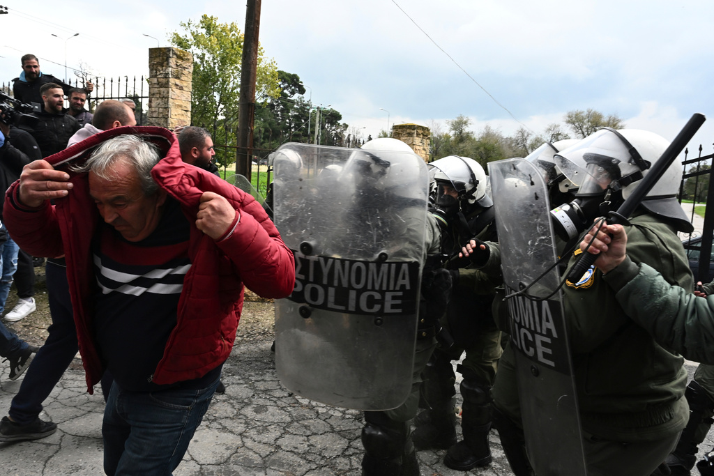 Riot police stop farmers trying to block the main access road to Thessaloniki's international airport, northern Greece, Friday, Dec. 5, 2025, as protests over delays in European Union-backed agricultural subsidy payments escalated. (AP Photo/Giannis Papanikos)