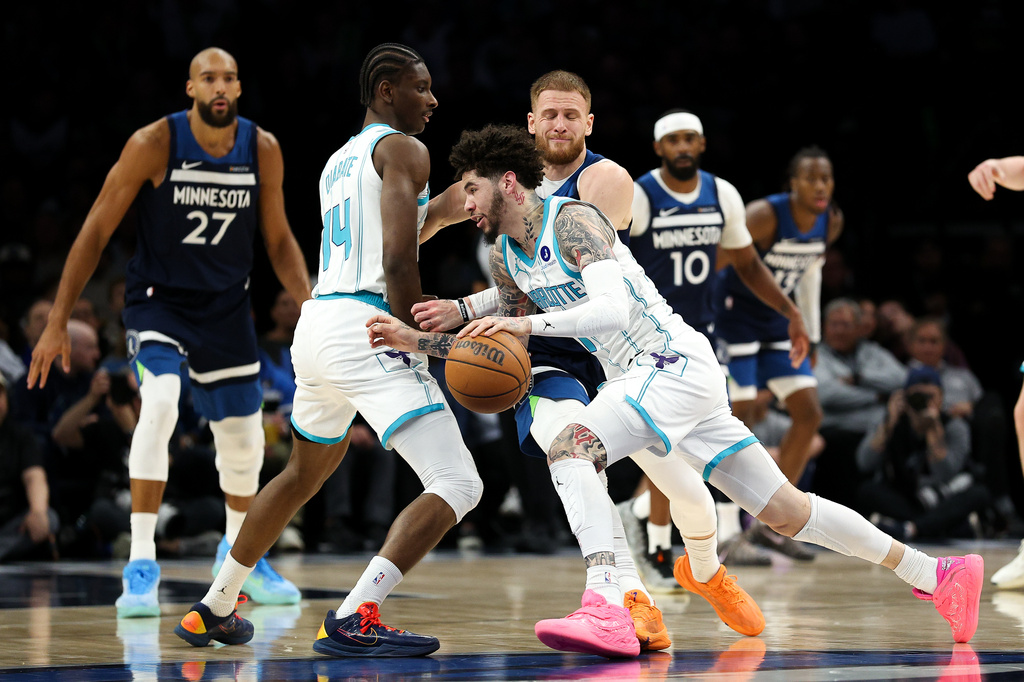 Charlotte Hornets guard LaMelo Ball (1) works around Minnesota Timberwolves guard Donte DiVincenzo (0) during the first half of an NBA basketball game, Sunday, April 5, 2026, in Minneapolis. (AP Photo/Matt Krohn)