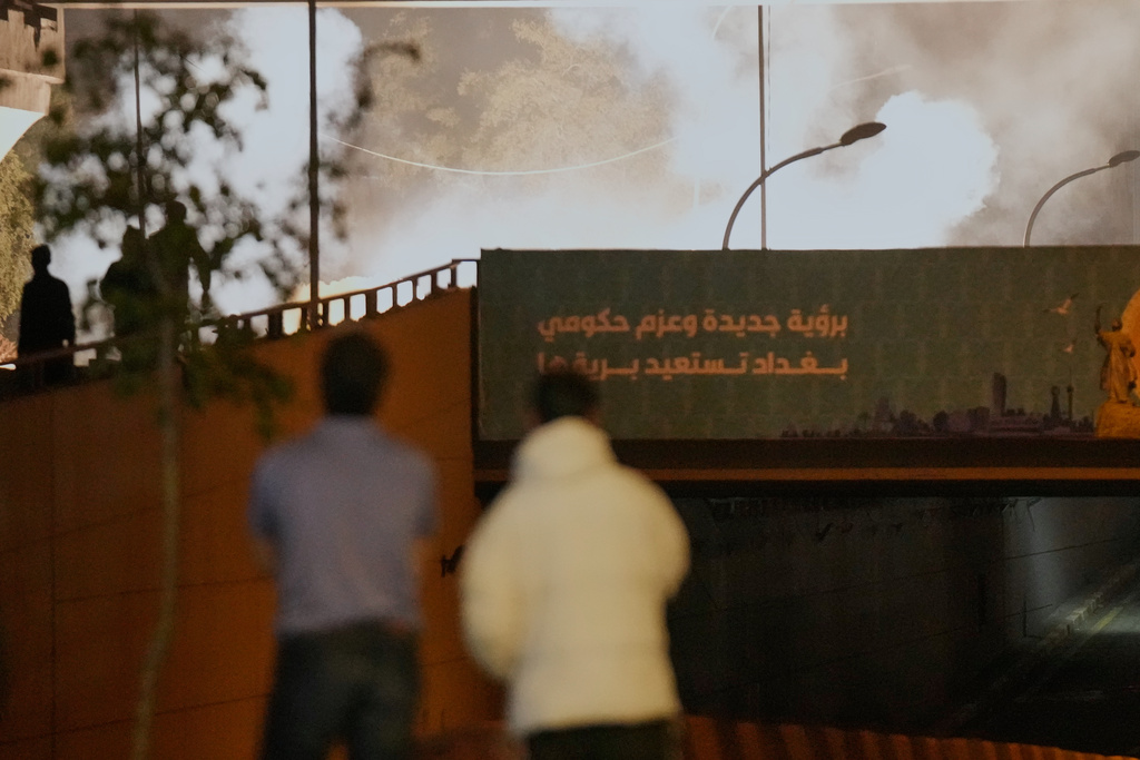 Security forces fire tear gas to disperse a protest against U.S. and Israeli attacks on Iran, at a bridge leading to the fortified Green Zone where the U.S. Embassy is located, in Baghdad, Iraq, Monday, March 2, 2026. (AP Photo/Hadi Mizban)