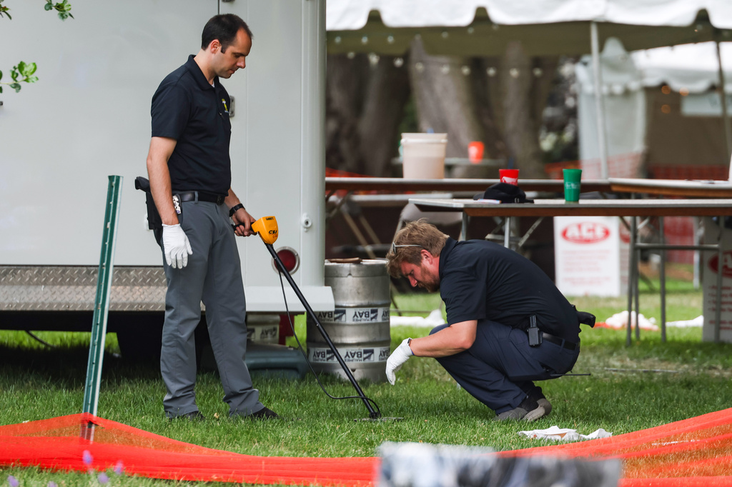Investigators use a metal detector to look for shells after a shooting that left 12 people injured at the Old West End Festival at the Agnes Reynolds Jackson Arboretum in Toledo, Ohio on Saturday, June 6, 2026. (Rebecca Benson/The Blade via AP)