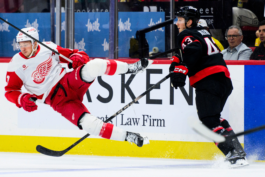 Detroit Red Wings' Lucas Raymond (23) is tripped by Ottawa Senators' Tyler Kleven (43) during second-period NHL hockey game action in Ottawa, Ontario, Monday, Jan. 5, 2026. (Spencer Colby/The Canadian Press via AP)