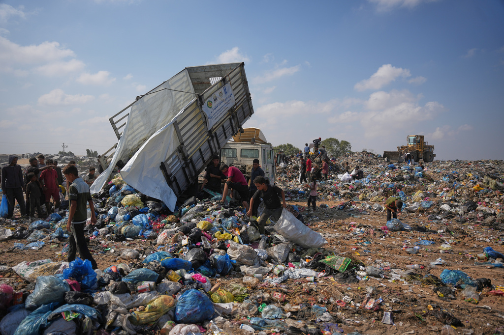 Palestinians search through a garbage dump for combustible materials to use as fuel for cooking due to a shortage of cooking gas, in Deir al-Balah, central Gaza Strip, Saturday, Aug. 22, 2026. (AP Photo/Abdel Kareem Hana)