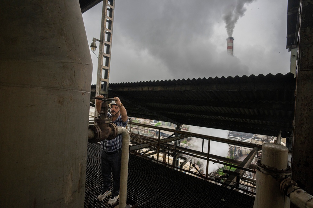 FILE - A technician releases a valve of a tank at Bajaj Hindustan Sugar factory that produces ethanol, a type of biofuel, in Meerut, India, Aug. 23, 2023. (AP Photo/Altaf Qadri, File)