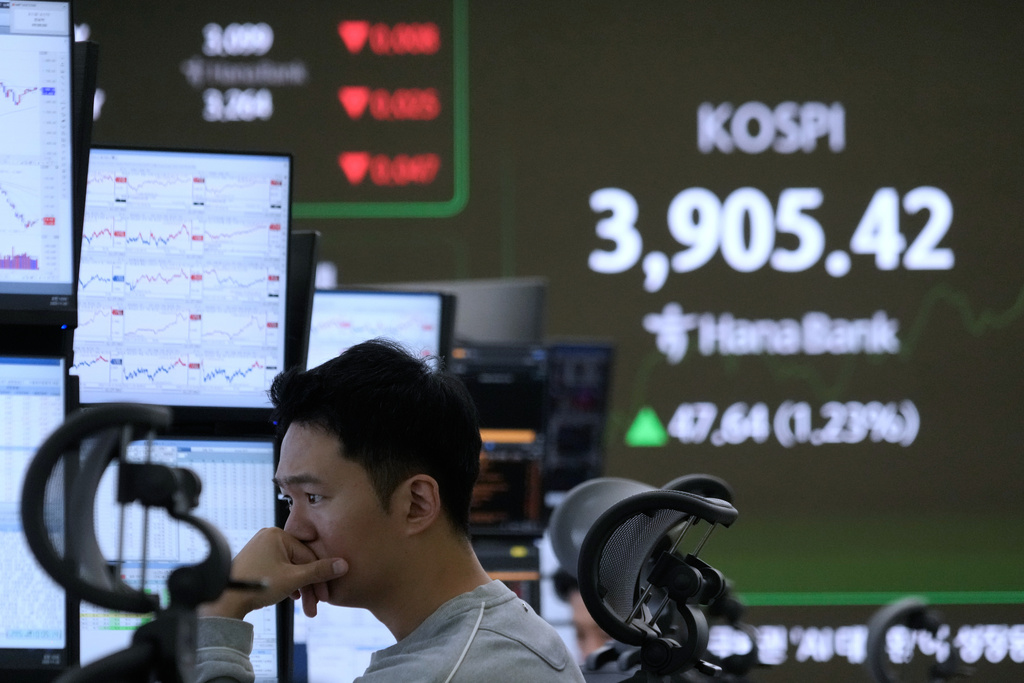 A currency trader watches monitors near a screen showing the Korea Composite Stock Price Index (KOSPI) at the foreign exchange dealing room of the Hana Bank headquarters in Seoul, South Korea, Wednesday, Nov. 26, 2025. (AP Photo/Ahn Young-joon)