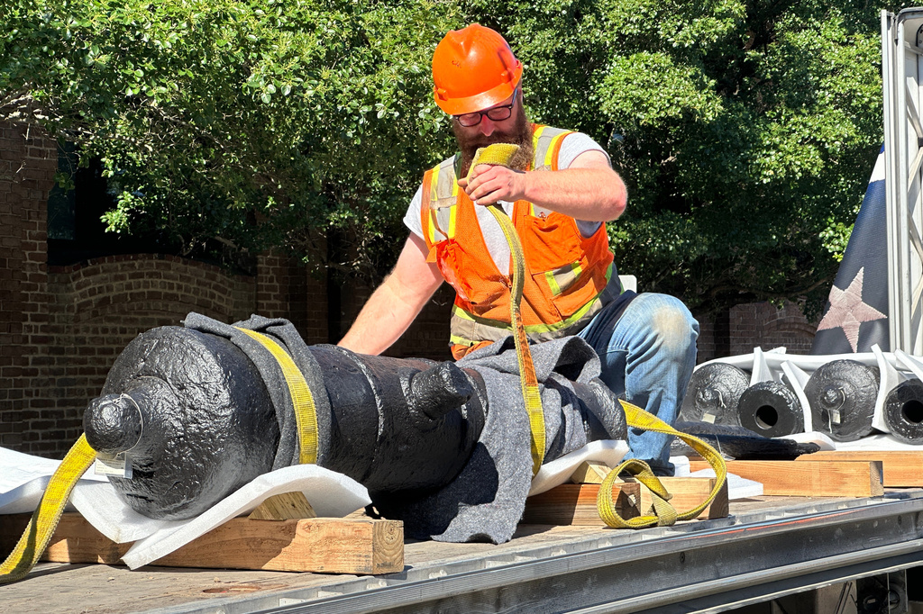 Bradford Shields fastens lifting straps to a cannon, which sunk to the bottom of the Savannah River during the American Revolution, on a flatbed truck at the Savannah History Museum in Savannah, Ga., on Wednesday, June 3, 2026. (AP Photo/Russ Bynum)