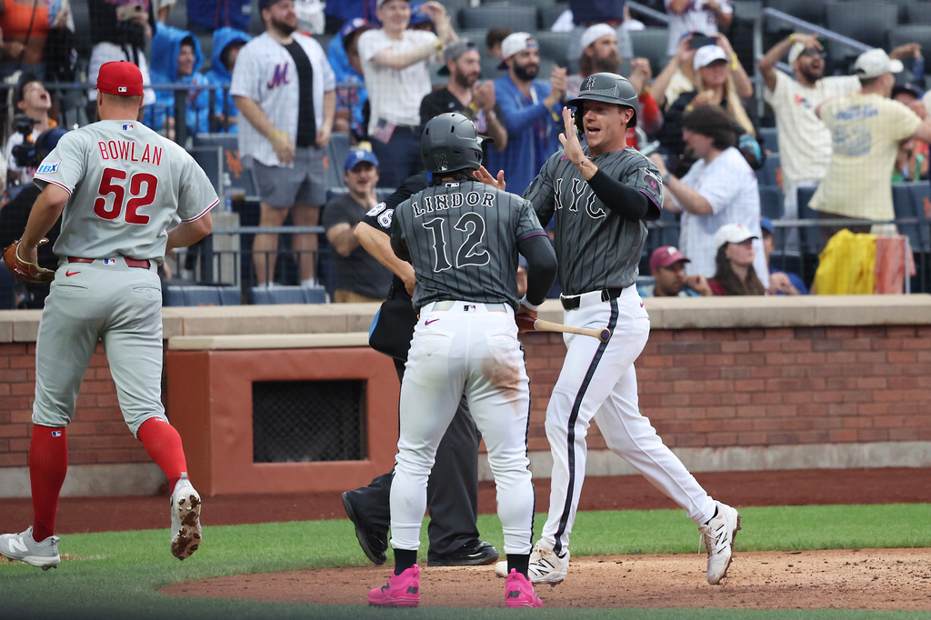 New York Mets' Jared Young, right, high-fives Francisco Lindor (12) after scoring during the sixth inning of a baseball game against the Philadelphia Phillies, Saturday, June 27, 2026, in New York. (AP Photo/Heather Khalifa)