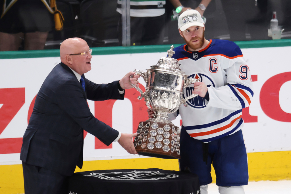FILE - Edmonton Oilers center Connor McDavid (97) is presented with the championship trophy after winning Game 5 of the Western Conference finals in the NHL hockey Stanley Cup playoffs against the Dallas Stars, May 29, 2025, in Dallas. (AP Photo/Gareth Patterson, file)
