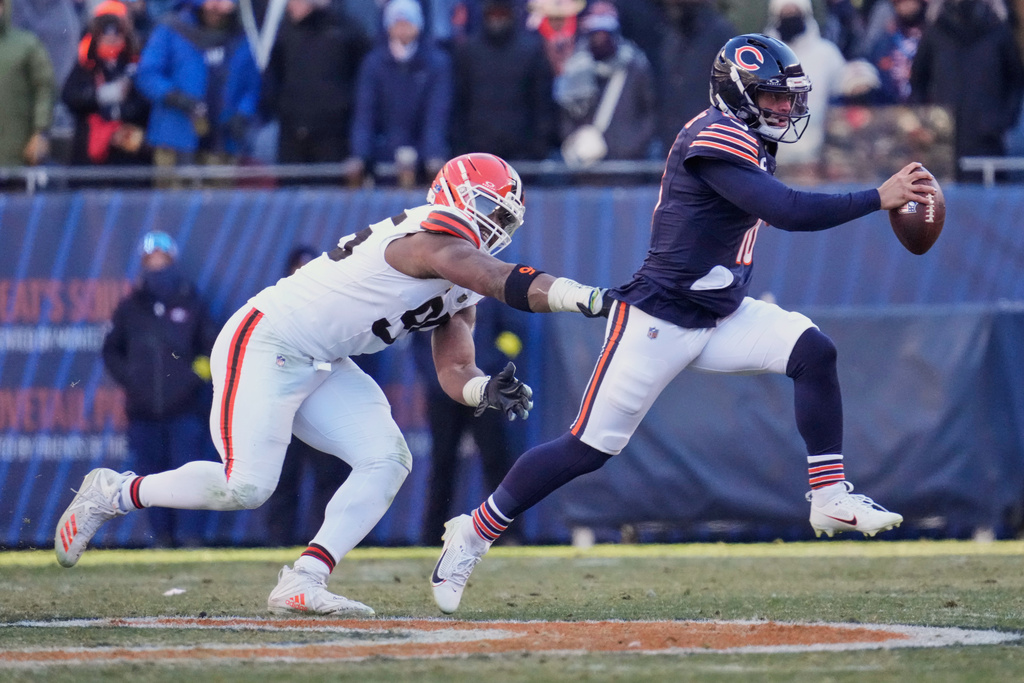 Chicago Bears quarterback Caleb Williams, right, avoids a tackle by Cleveland Browns defensive end Myles Garrett, left, in the second half of an NFL football game in Chicago, Sunday, Dec. 14, 2025. (AP Photo/Nam Y. Huh)