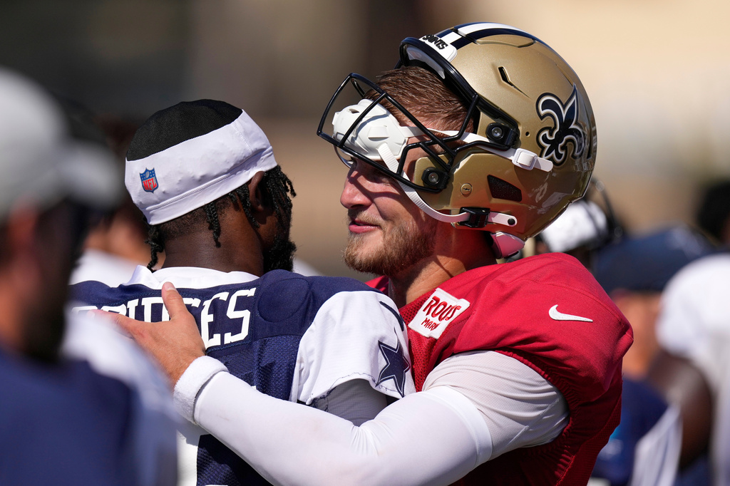 Dallas Cowboys cornerback Trikweze Bridges, left, greets New Orleans Saints quarterback Tyler Shough during an NFL football joint practice, Tuesday, Aug. 18, 2026, in Oxnard, Calif. (AP Photo/Mark J. Terrill)