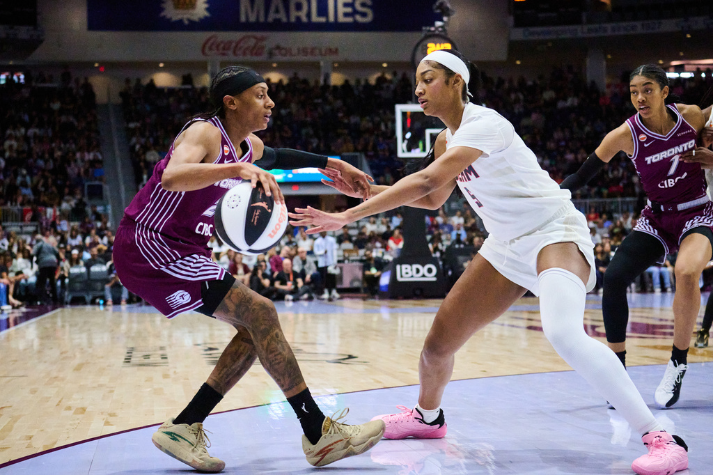 Toronto Tempo's Brittney Sykes, left, keeps the ball from Atlanta Dream's Angel Reese, second from left, during the first half of a WNBA basketball game in Toronto, Sunday, June 14, 2026. (Sammy Kogan/The Canadian Press via AP)