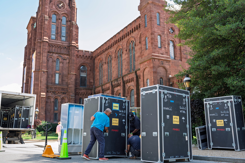 Workmen load shipping crates with items from the Smithsonian Institution building, more commonly known as the Smithsonian Castle, as it closed for renovations, in Washington, Tuesday, Sept. 8, 2026. (AP Photo/J. Scott Applewhite)