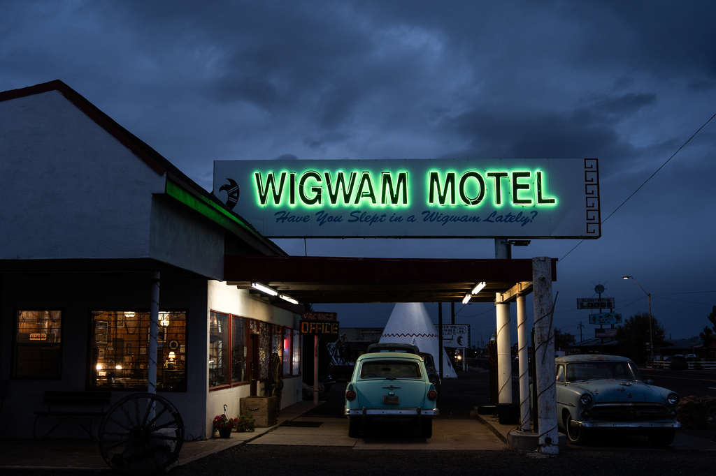 Vintage cars sit beneath a neon sign at the Wigwam Motel, a landmark along historic Route 66, in Holbrook, Ariz., Wednesday, Nov. 19, 2025. (AP Photo/Jae C. Hong)