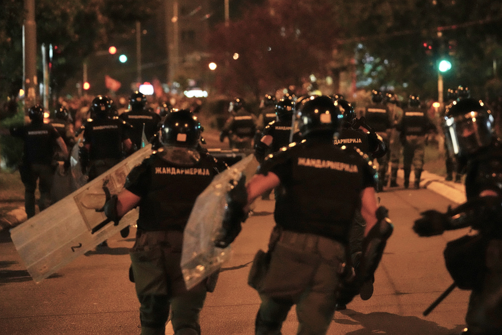 Serbian gendarmerie officers chase protesters during an anti-government protest in Belgrade, Serbia, Monday, Aug. 18, 2025. (AP Photo/Darko Vojinovic)