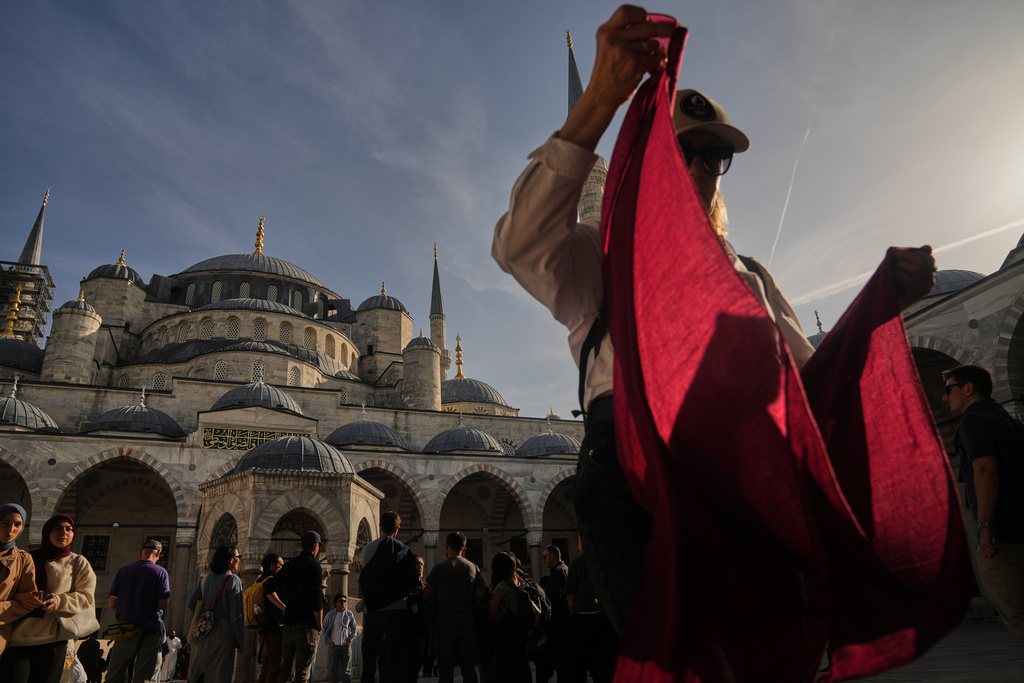 Locals and tourists visit the Ottoman-era Sultan Ahmed or Blue Mosque, in Istanbul, Turkey, Friday, Nov. 21, 2025, ahead of the visit of Pope Leo XIV to Turkey. (AP Photo/Francisco Seco)