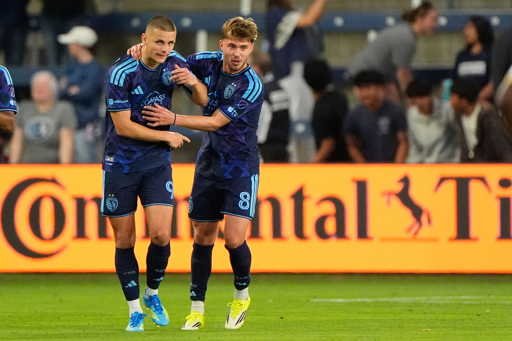 Sporting Kansas City forward Dejan Joveljic (9) and defender Jake Davis (8) celebrate after Joveljic scored a goal during the first half of an MLS soccer match against LA Galaxy, Wednesday, May 13, 2026, in Kansas City, Kan. (AP Photo/Charlie Riedel)