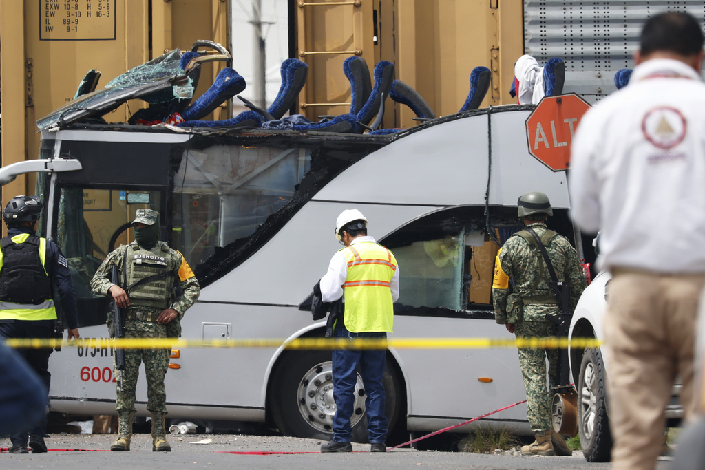 Soldiers and rescue personal work the scene of a deadly accident where a freight train slammed into a double-deck bus in Atlacomulco, Mexico, Monday, Sept. 8, 2025. (AP Photo/Ramses Mercado Valdes)