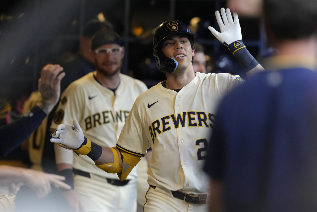 Milwaukee Brewers' Christian Yelich is congratulated in the dugout after hitting a solo home run during the third inning of a baseball game against the Pittsburgh Pirates, Monday, Aug. 11, 2025, in Milwaukee. (AP Photo/Aaron Gash)