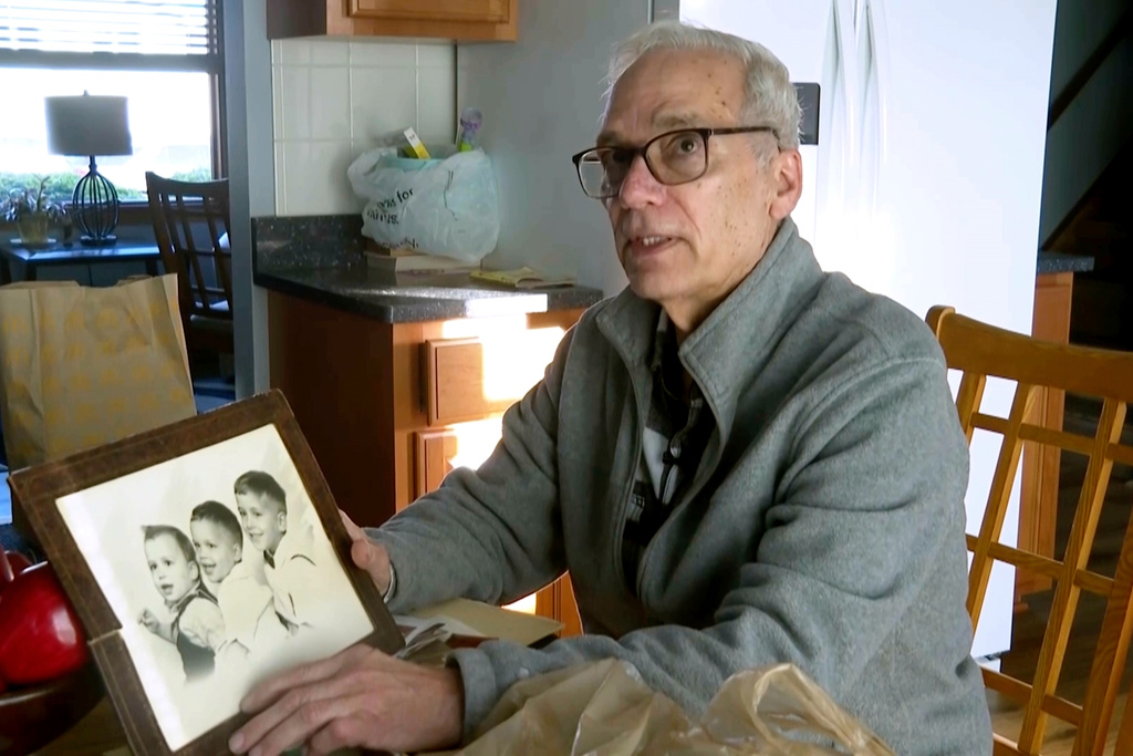 FILE - John Prevost, brother of new Pope Leo XIV, holds a portrait of the three Prevost brothers from 1958, Pope Leo, 3, left, John, 4, and Louis, 7, at his home, May 8, 2025, in New Lenox, Ill. (AP Photo/Obed Lamy, File)