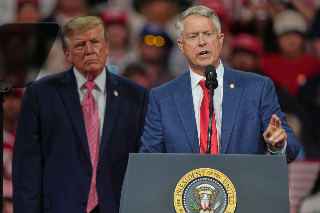 President Donald Trump listens as Sen. Roger Marshall, R-Kan., speaks at a campaign rally at Heartland Credit Union Arena, Monday, Oct. 19, 2026, in Park City, Kan. (AP Photo/Charlie Riedel)