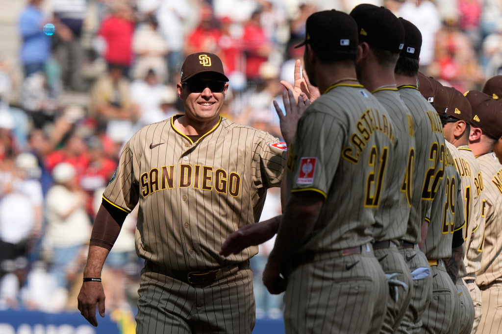 San Diego Padres' coach Craig Stammen, left, enters the field prior to a baseball game against Arizona Diamondbacks in Mexico City, Saturday, April 25, 2026. (AP Photo/Fernando Llano)