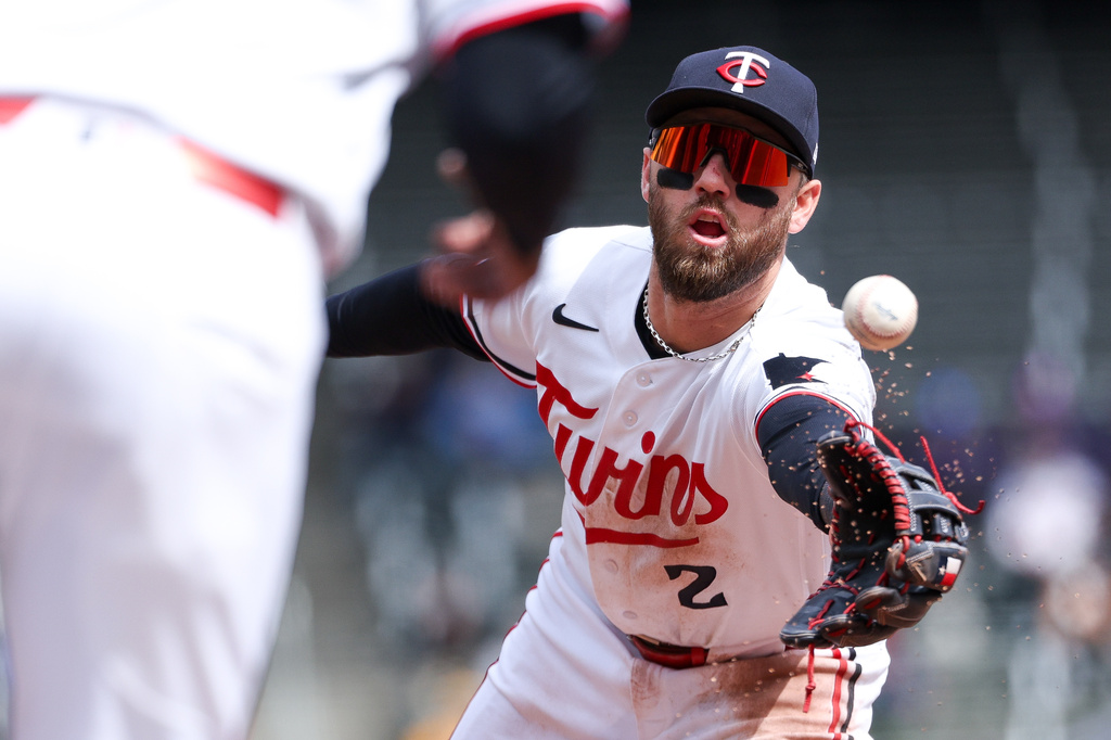 Minnesota Twins second baseman Kody Clemens flips the ball to first base to get the out on Detroit Tigers' Zach McKinstry during the fourth inning of baseball game, Thursday, April 9, 2026, in Minneapolis. (AP Photo/Matt Krohn)