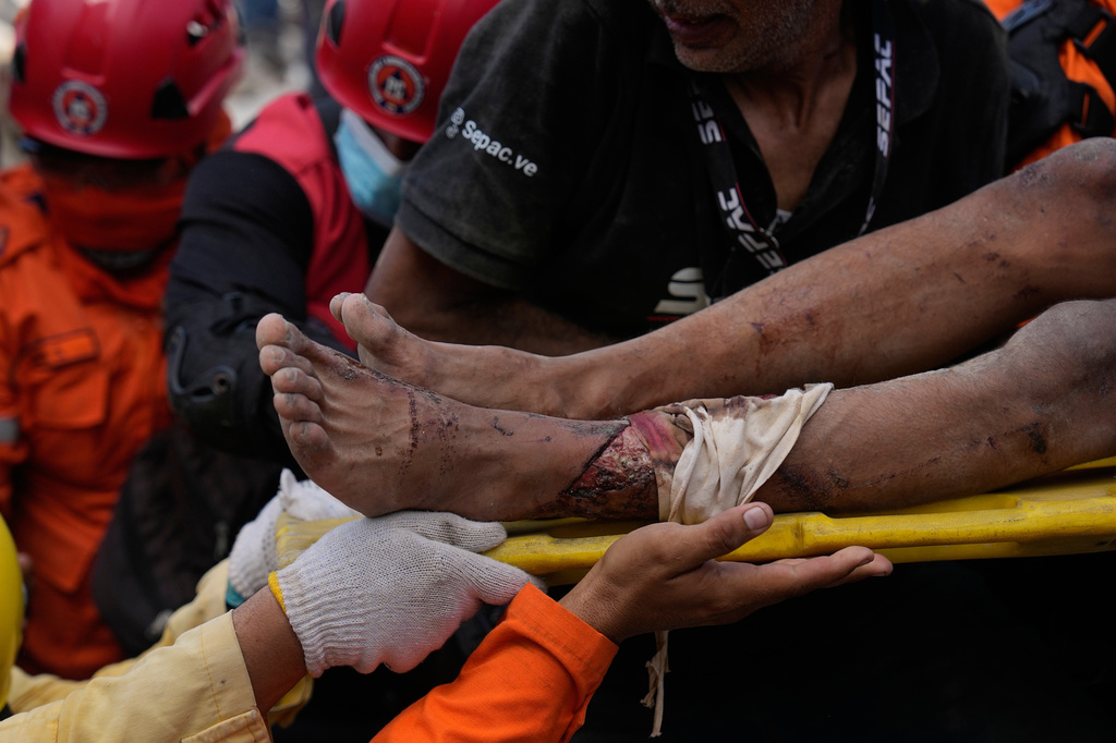 Rescue workers carry Patrick Vargas after pulling him from the rubble two days after an earthquake struck Catia la Mar, Venezuela, Friday, June 26, 2026. (AP Photo/Fernando Vergara)