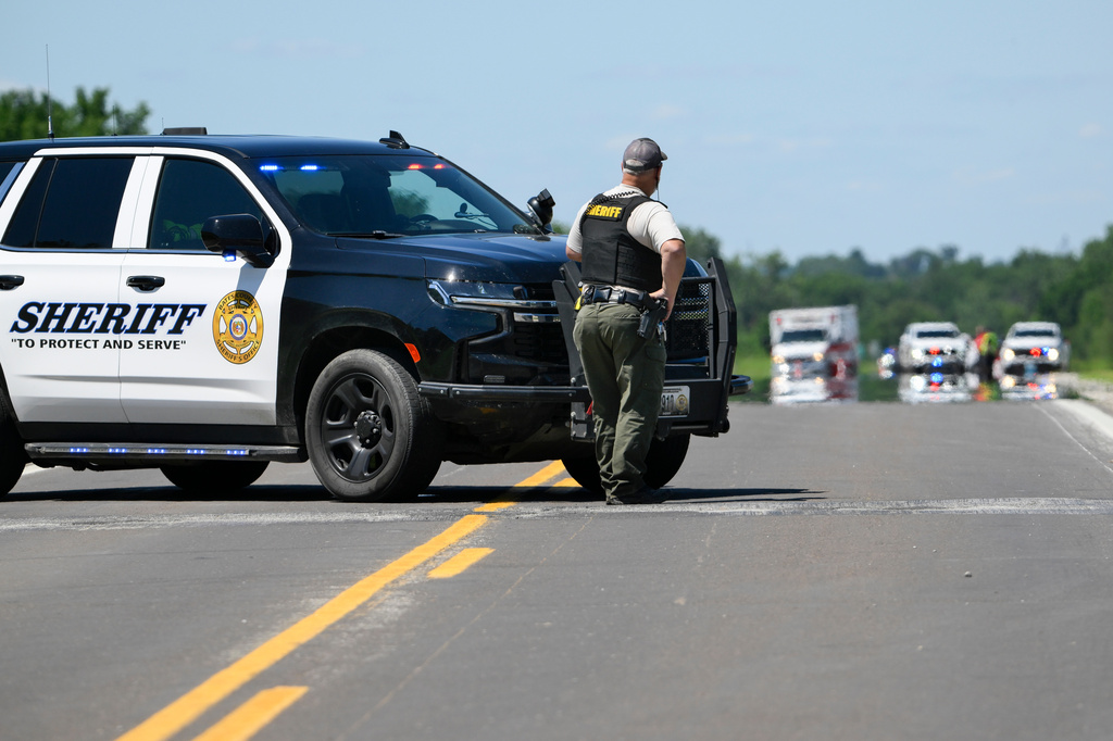 A Bates County Sheriff's Deputy mans a roadblock outside the scene of a plane crash at Butler Memorial Airport in Butler, Mo., Sunday, June 14, 2026. (AP Photo/Reed Hoffmann)