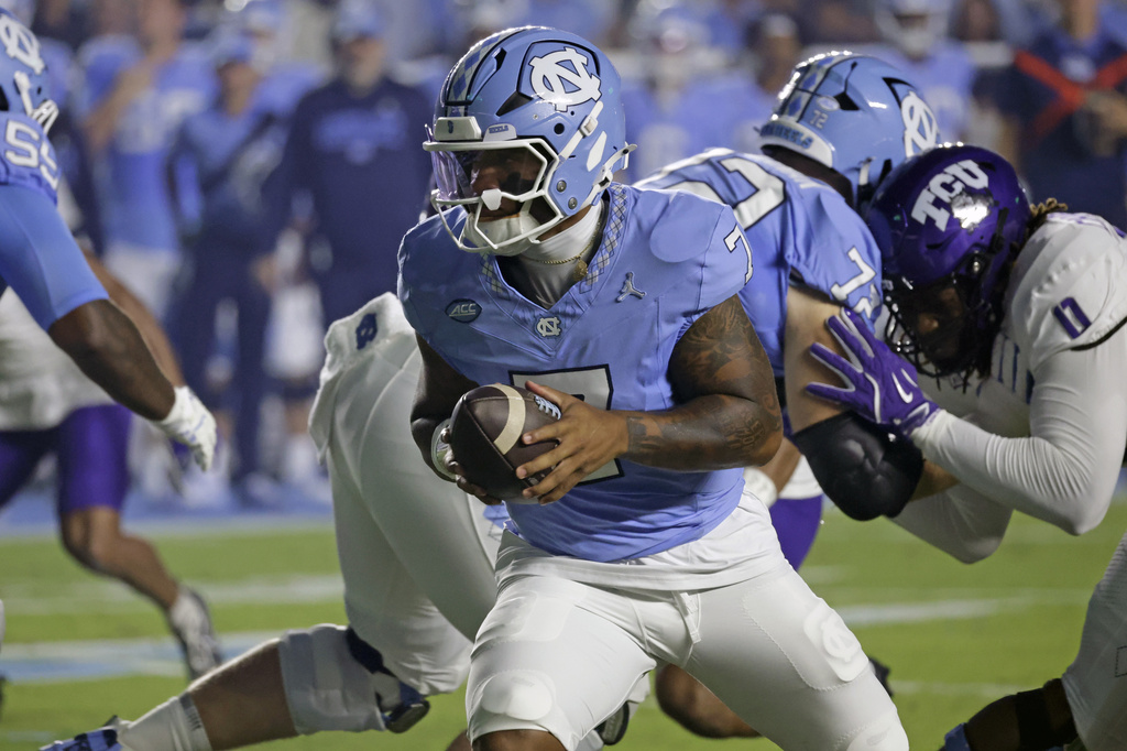 North Carolina quarterback Gio Lopez, center, looks to hand off the ball during the first half of an NCAA college football game against TCU, Monday, Sept. 1, 2025, in Chapel Hill, N.C. (AP Photo/Chris Seward)
