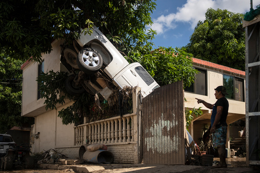 A pickup truck hangs over a fence in Poza Rica, Veracruz state, Mexico, Sunday, Oct. 12, 2025, after rain and flooding. (AP Photo/Felix Marquez) A pickup truck hangs over a fence in Poza Rica, Veracruz state, Mexico, Sunday, Oct. 12, 2025, after rain and flooding. (AP Photo/Felix Marquez)
