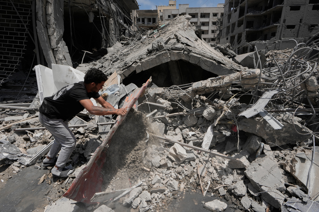 A man removes debris of a building that was hit Monday in an Israeli airstrike in the southern port city of Tyre, Lebanon, Tuesday, June 2, 2026. (AP Photo/Mohammed Zaatari)