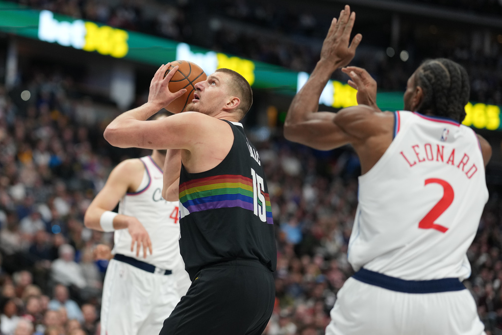 Denver Nuggets center Nikola Jokić (15) goes up for a basket as Los Angeles Clippers forward Kawhi Leonard (2) defends in the first half of an NBA basketball game Friday, Jan. 30, 2026, in Denver. (AP Photo/David Zalubowski)