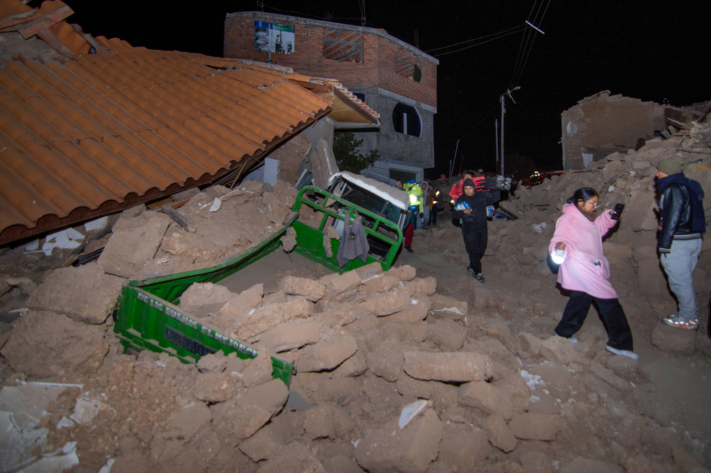 Residents walk amid the debris of homes that collapsed after an earthquake struck Pumpuya, Peru, Sunday, July 19, 2026. ( AP Photo/Javier Ninanya)