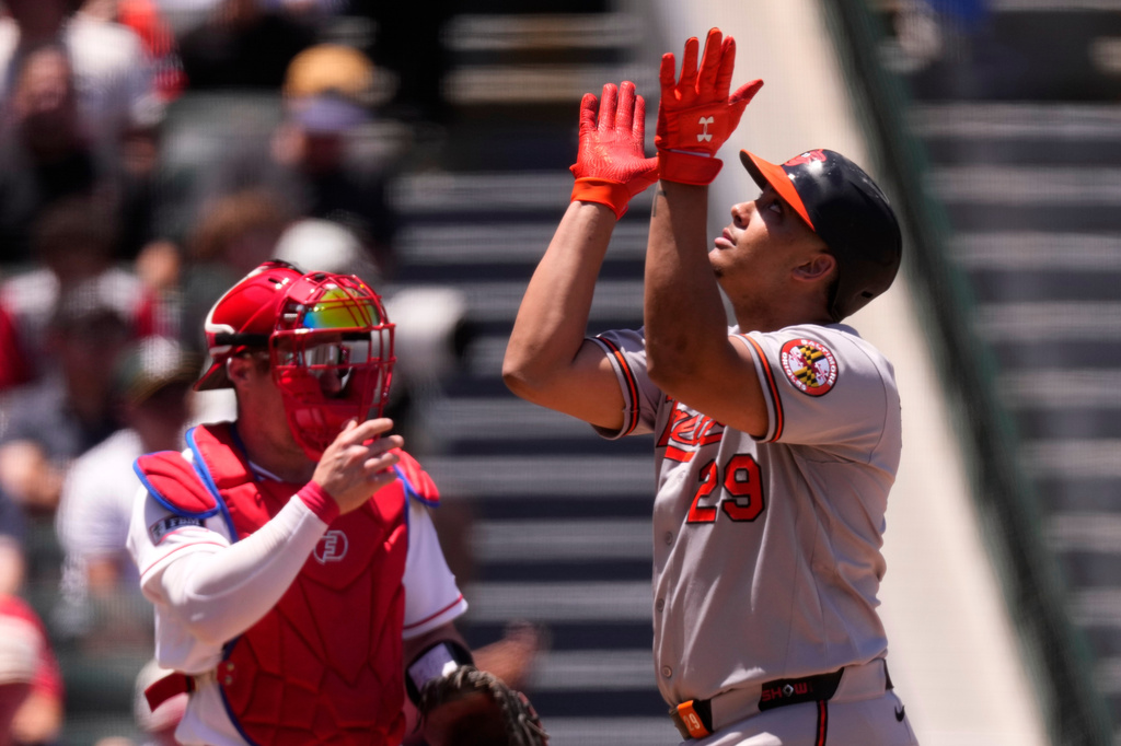 Baltimore Orioles' Samuel Basallo, right, gestures as he scores after hitting a two-run home run as Los Angeles Angels catcher Tyler Heineman stands by during the second inning of a baseball game Wednesday, June 24, 2026, in Anaheim, Calif. (AP Photo/Mark J. Terrill)