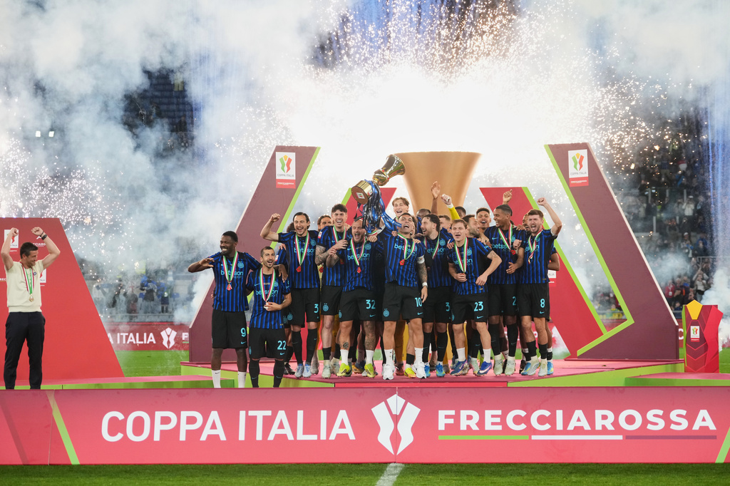Inter Milan's team captain Lautaro Martinez lifts the trophy while Inter Milan head coach Cristian Chivu at left celebrates after defeating Lazio to win the Italian Cup soccer final in Rome, Wednesday, May 13, 2026. (AP Photo/Andrew Medichini)
